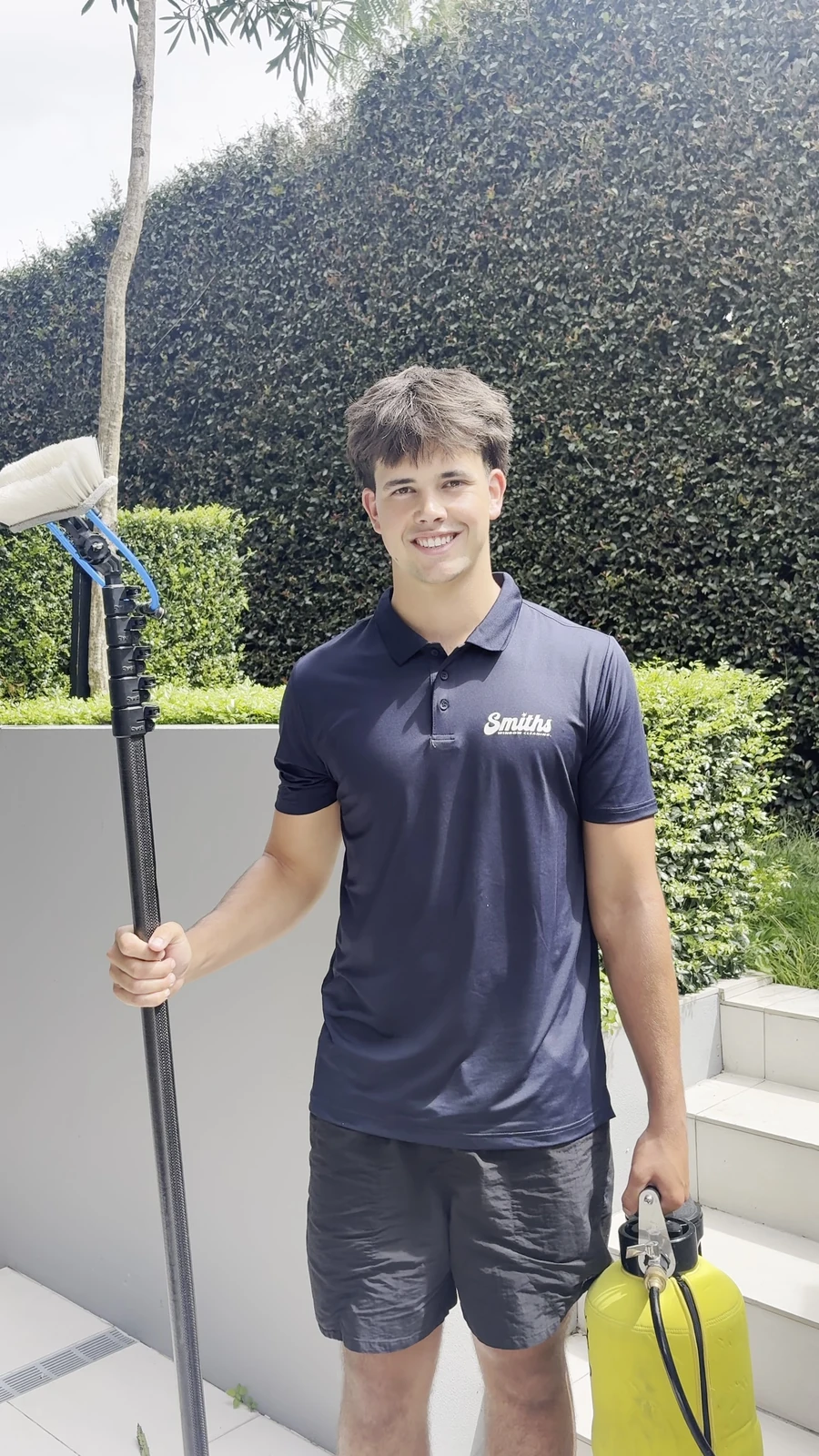 Ashton Smith, founder of Smiths Window Cleaning, holding a water fed pole brush